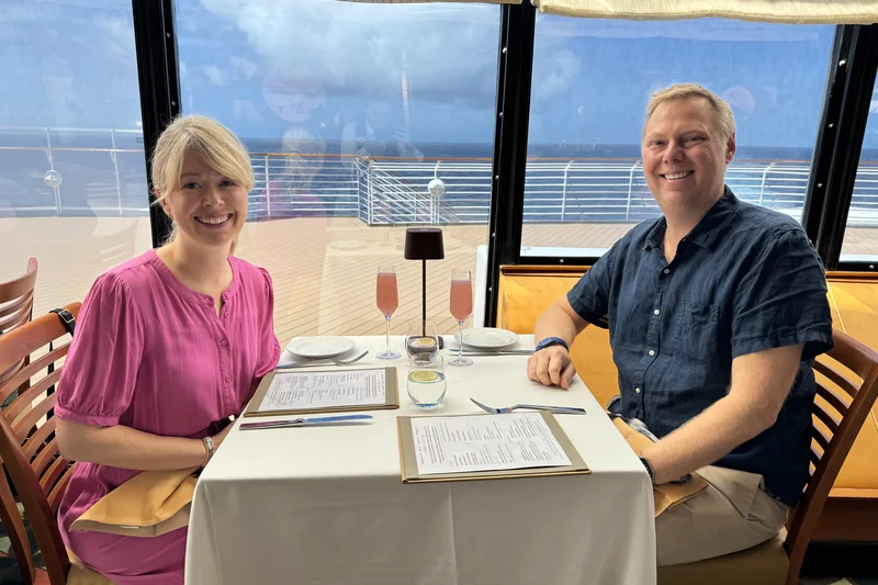 The two of us at a window table at dinner, open ocean behind the glass