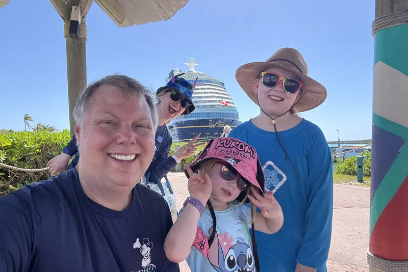 Family at a port stop with the cruise ship behind
